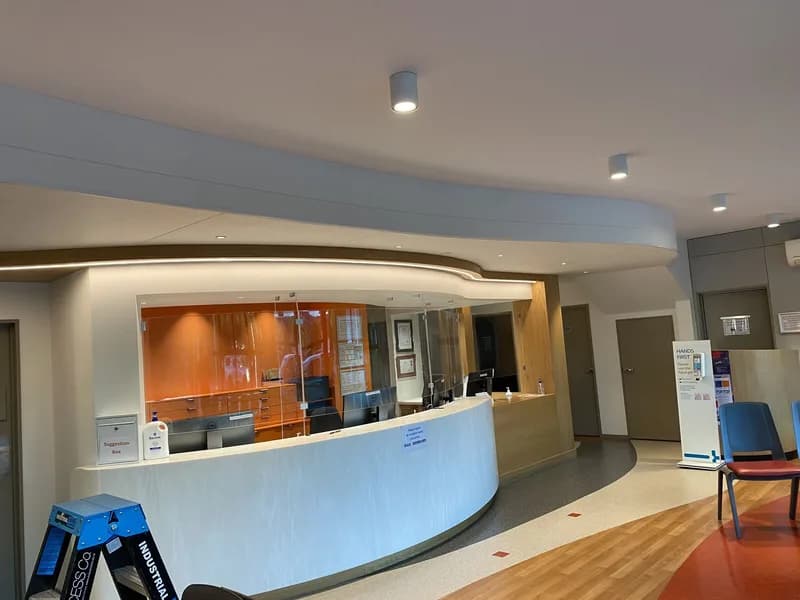 Finished double-curve wavy ceiling above the curved reception desk at Riccarton Doctors